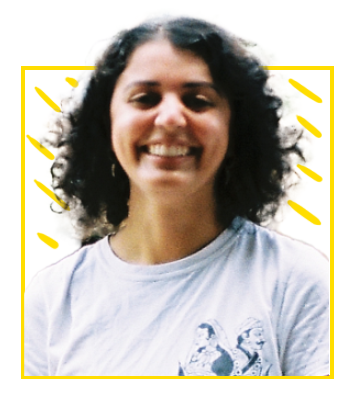 Headshot: Priya Biring – a woman of colour with dark, shoulder-length curly hair, wearing a white t-shirt.